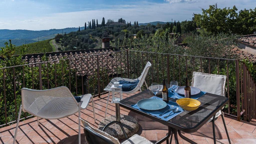 een tafel en stoelen op een balkon met uitzicht bij Pesci in Gaiole in Chianti