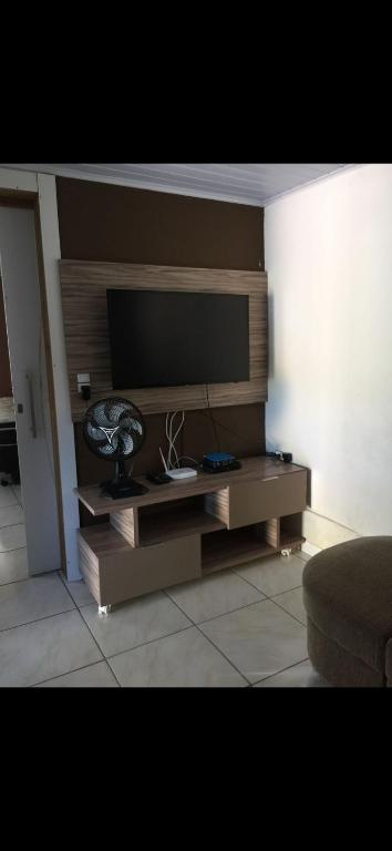 Una sala de estar con un televisor de pantalla plana en una pared. en Casa1, en Itapema