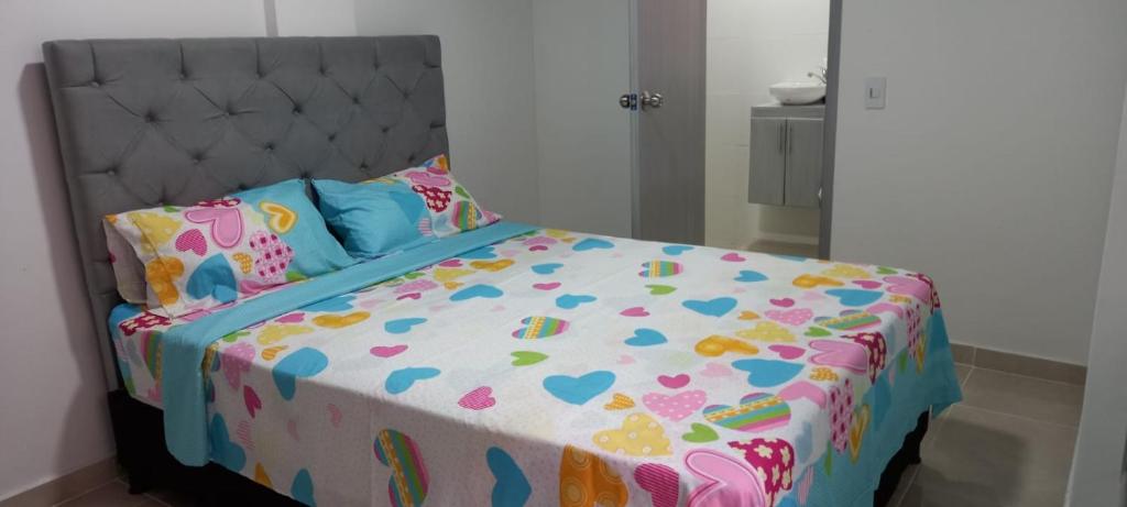 ein Schlafzimmer mit einem Bett mit einer Bettdecke mit Herz in der Unterkunft Hospedaje Flor Amarillo in Villavicencio