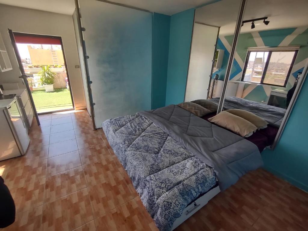 um quarto com uma cama numa parede azul em Abu alzoz home سكن مشترك em Amã