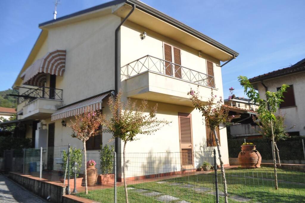 ein weißes Haus mit einem Zaun davor in der Unterkunft La Casa di Tommy in Monsagrati