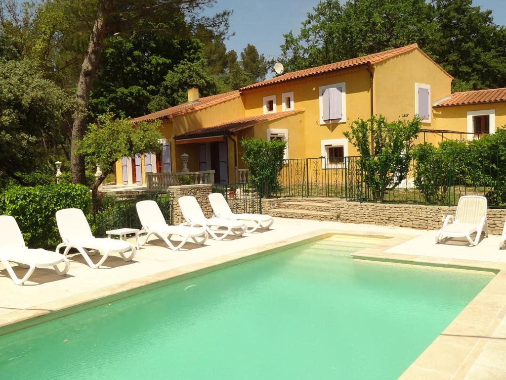 een zwembad met stoelen en een huis op de achtergrond bij Maison L'Isle-sur-la-Sorgue, 6 pièces, 8 personnes - FR-1-708-57 in LʼIsle-sur-la-Sorgue