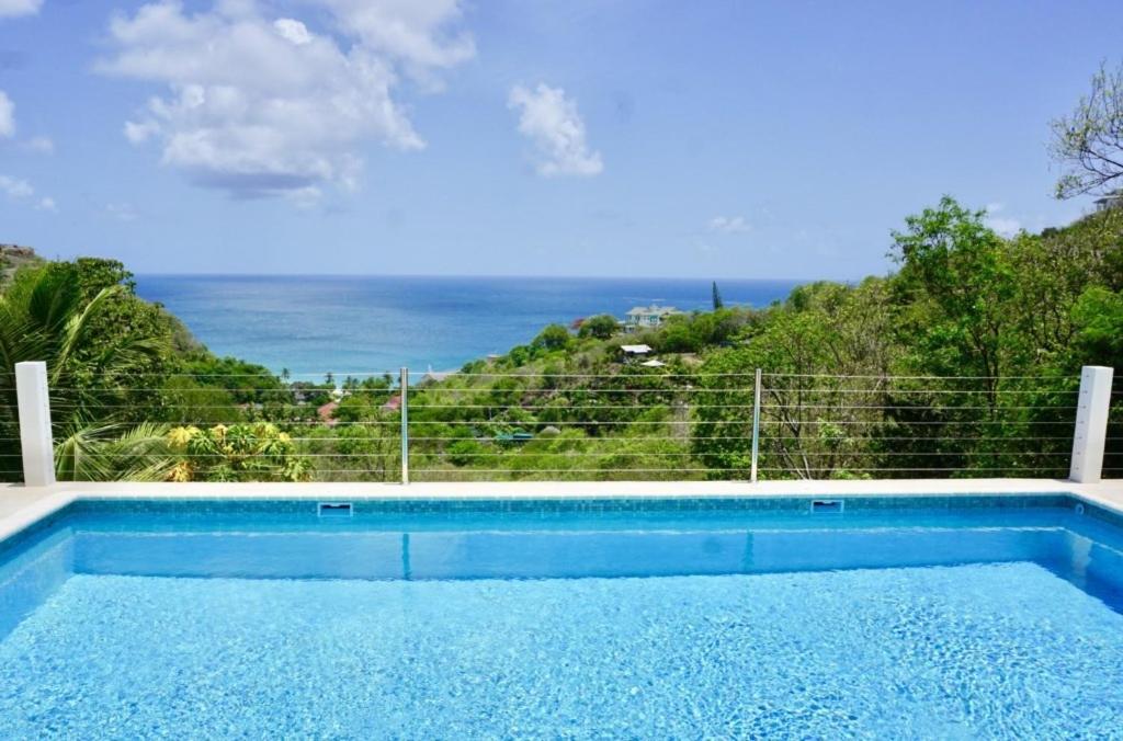 una piscina con vista al mar en La Mer - Bright & Modern 3 bedroom Caribbean Villa villa, en Cap Estate