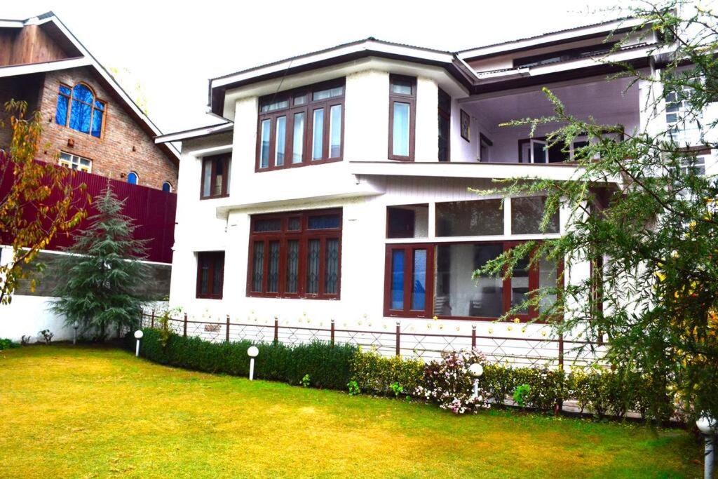 ein weißes Haus mit einem Hof davor in der Unterkunft Feather Stays - 4 BHK Apartment in a Villa in Srinagar
