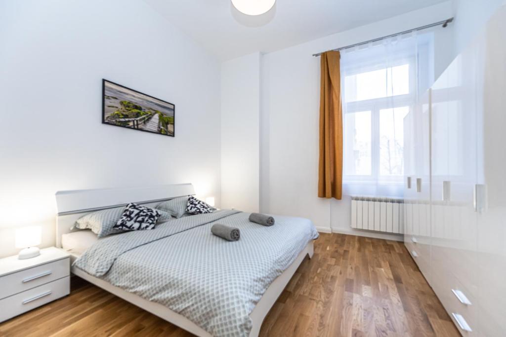um quarto branco com uma cama e uma janela em Cozy apartment in the heart of Prague em Praga