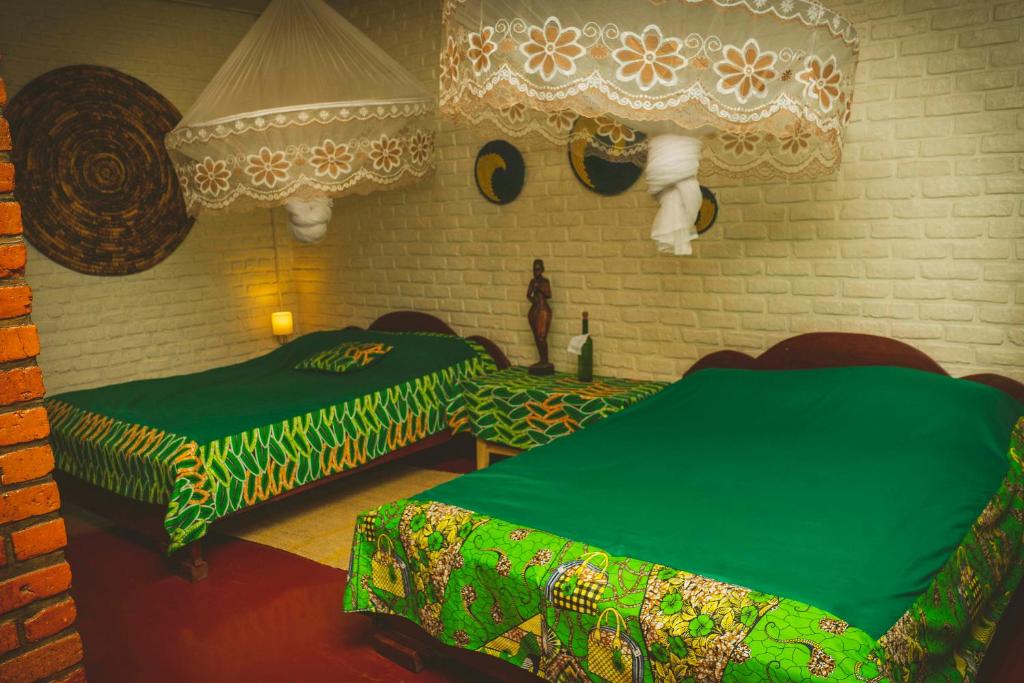 1 Schlafzimmer mit 2 Betten und grüner Bettwäsche in der Unterkunft Room in Guest room - Isange Paradise Resort in Ruhengeri