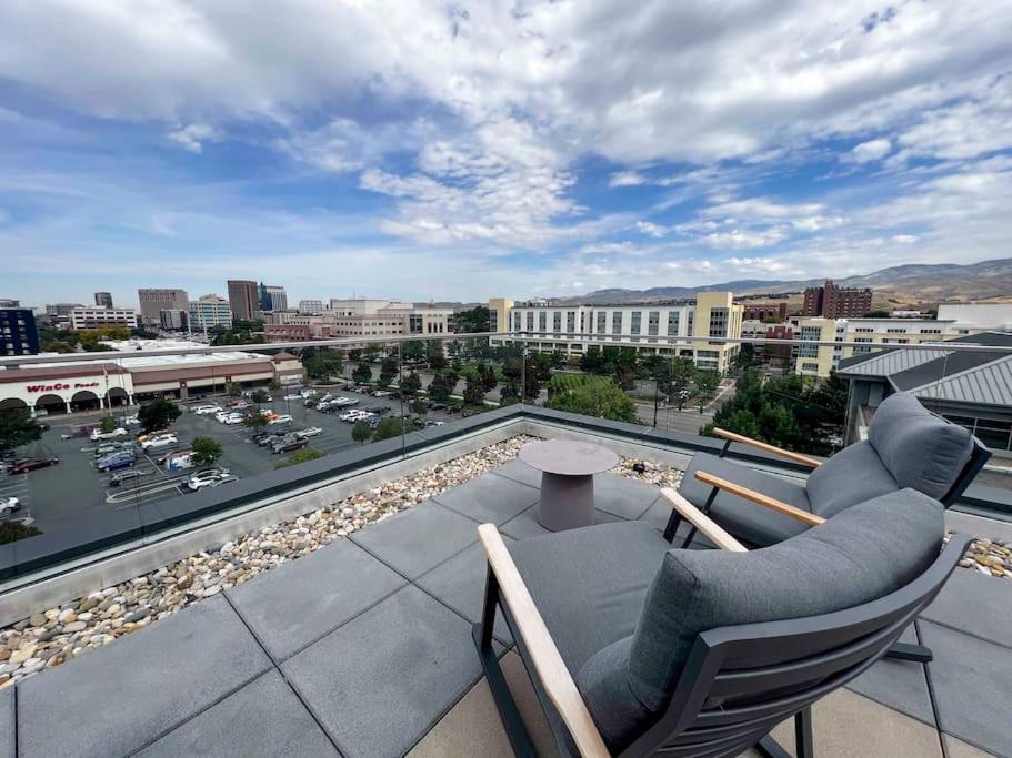 a balcony with two chairs and a view of a city at Boho-Luxe Studio - Pink Accents & Mountain Calm in Boise
