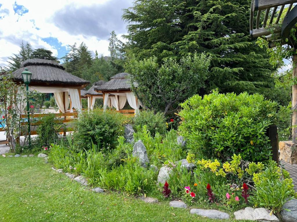 - un jardin avec deux kiosques et des fleurs dans l'établissement El Carmelo Mountain Lodge, à Potrerillos