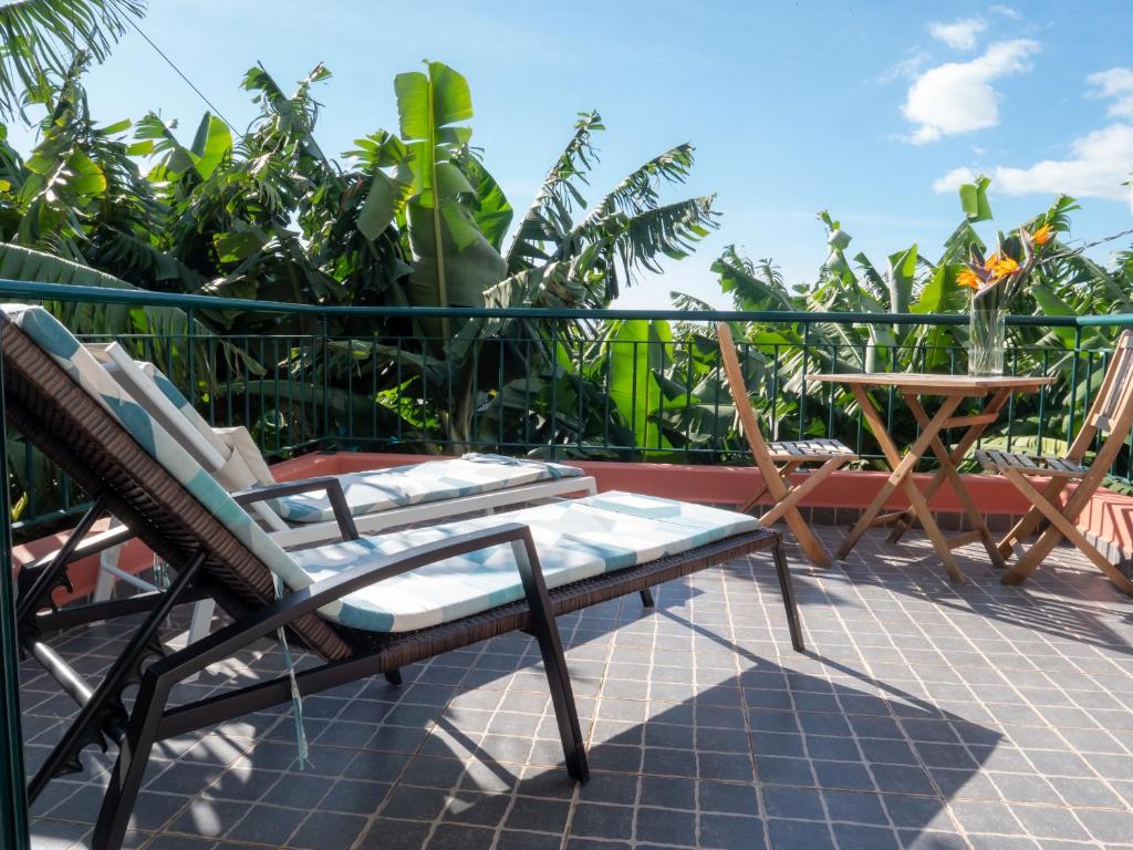 patio z krzesłami i stołem na balkonie w obiekcie Casa dos Anjos w mieście Ponta do Sol
