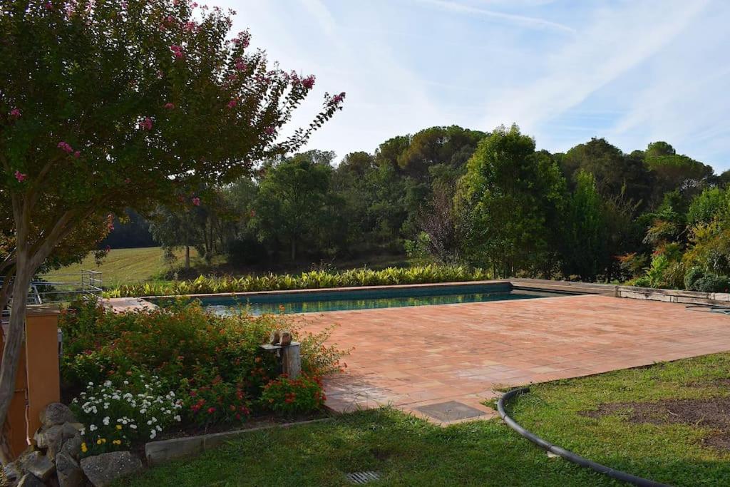 uma piscina num quintal com jardim em Can Figueretes em Caldes de Malavella
