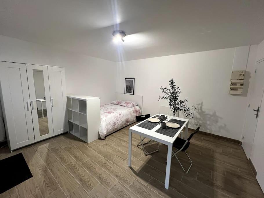 a bedroom with a bed and a desk and a table at Appartement proche tramway in Vitry-sur-Seine