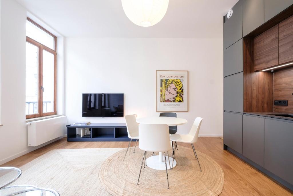 a white kitchen with a table and chairs at The Duke flats - 1 bedroom apartments Grand Place in Brussels