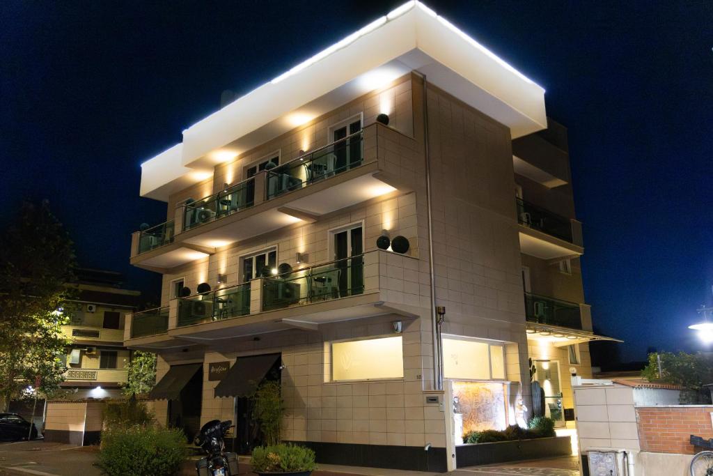 un gran edificio blanco con balcón por la noche en Porto Di Claudio, en Fiumicino