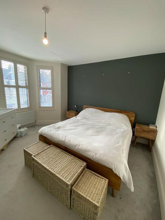 een slaapkamer met een groot bed en 2 ramen bij Stunning 4BD House wLarge Garden - Finsbury Park! in Londen