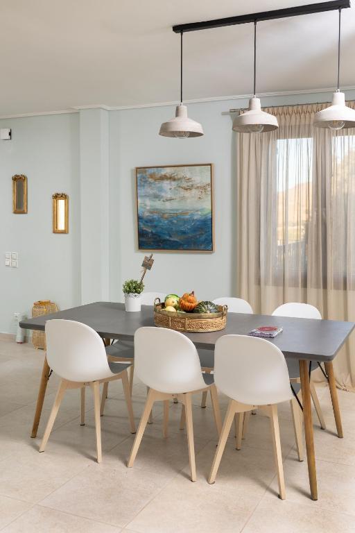 a dining room with a black table and white chairs at Lampetos Houses Molyvos in Mythimna