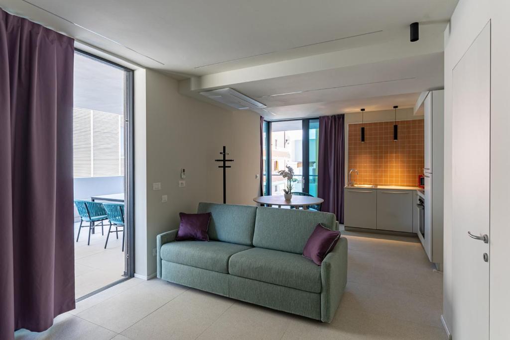 格拉多的住宿－Aparthotel Zefiro com design, large terrace, bike, near beach and thermal，带沙发的客厅和厨房