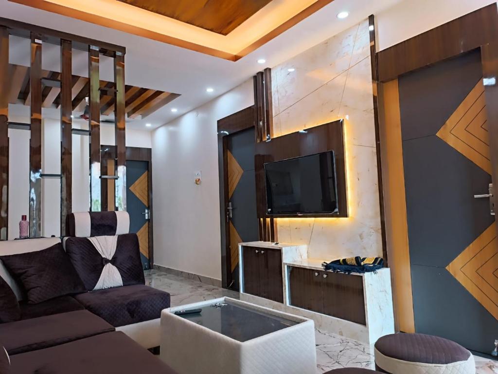 a living room with a couch and a tv at Alif serviced Apartment for Families and Executives in Tambaram