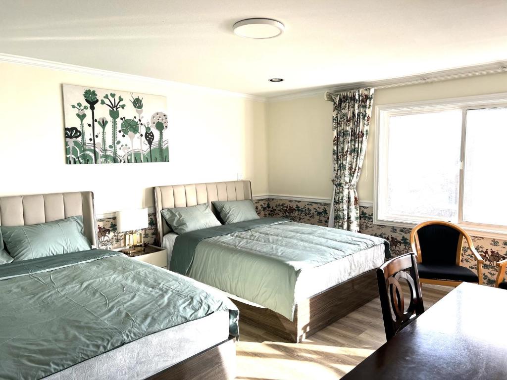 a bedroom with two beds and a table at Master Bedroom with Two Queen Sized Bed in Richmond