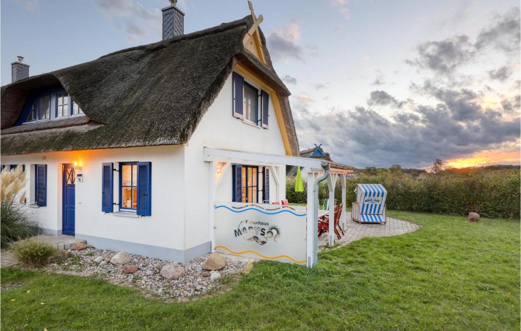 a small white house with a thatched roof at Nice Home In Zierow Ot Poeler Drift With 2 Bedrooms, Sauna And Wifi in Zierow