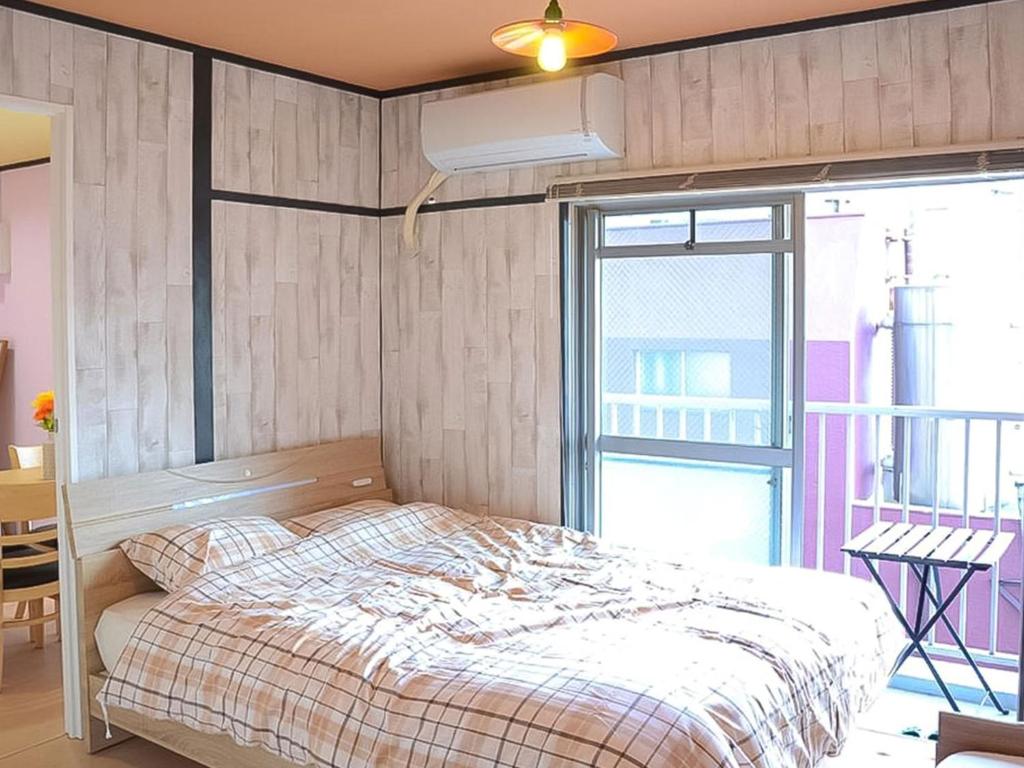 1 dormitorio con cama y ventana grande en Calm House Beppu Kitahama - Vacation STAY 06895v, en Beppu