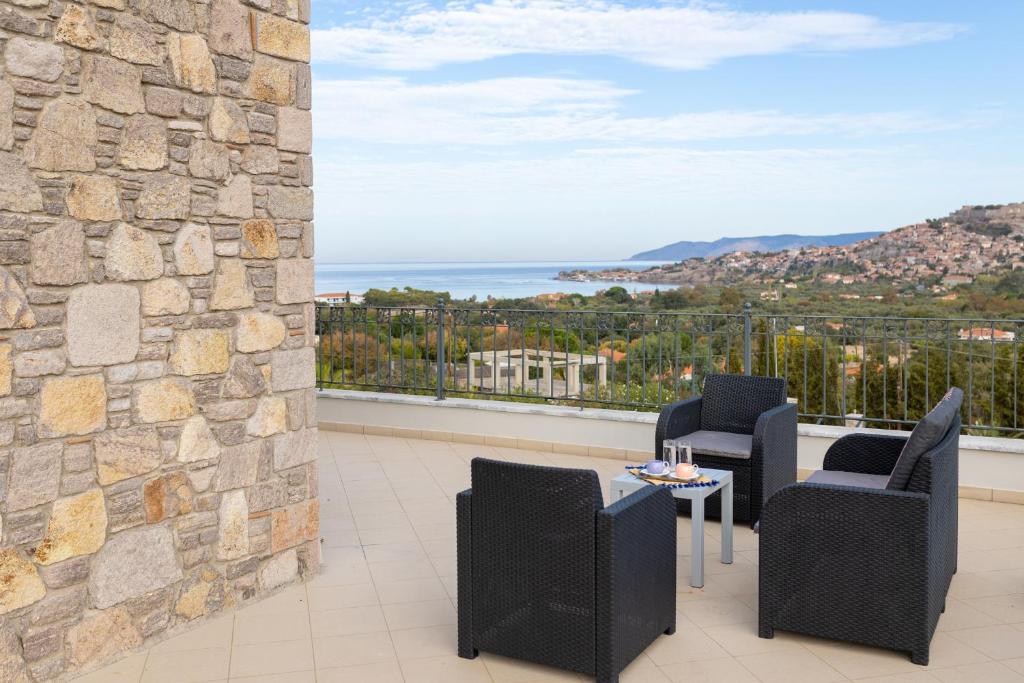 a balcony with two chairs and a table with a view at Lampetos Houses Molyvos in Mythimna