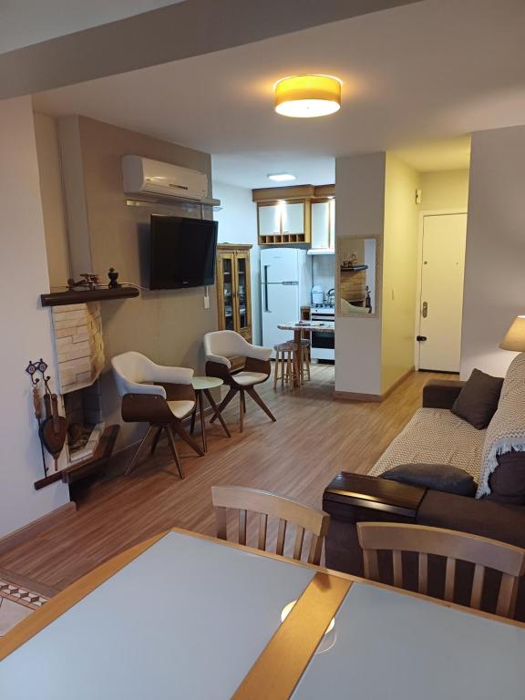 a living room and kitchen with a couch and a table at Ap dos primos in Capão da Canoa