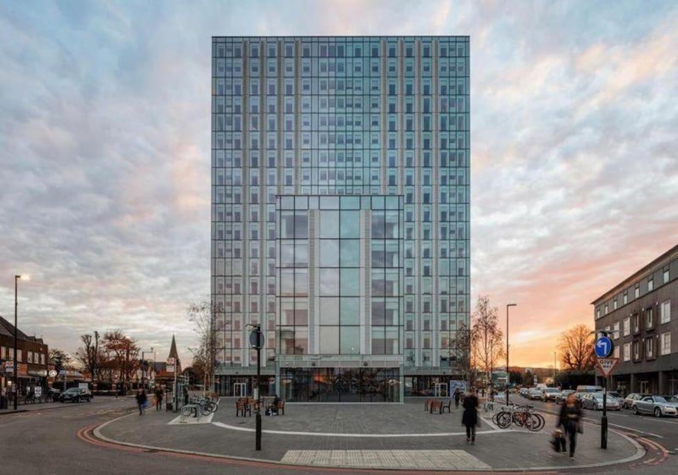 a tall building with people walking in front of it at Brand new apartment 20 mins from London Waterloo BP34 in London