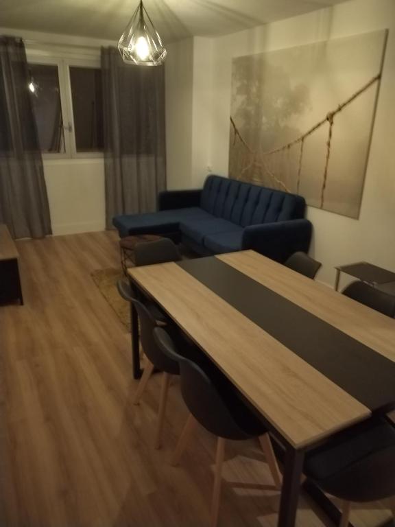 ein Wohnzimmer mit einem blauen Sofa und einem Tisch in der Unterkunft T4 Prado vélodrome plage 3 chambres in Marseille