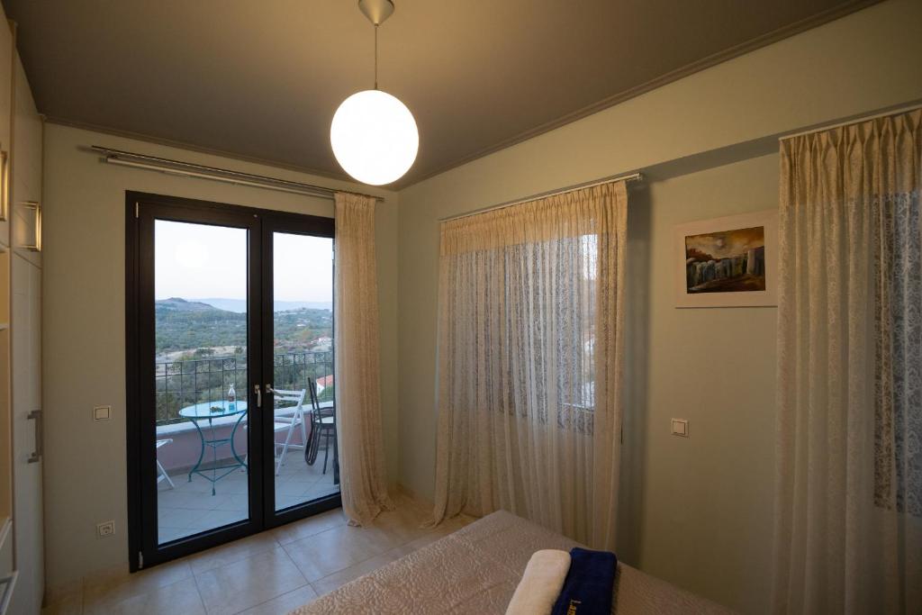 a bedroom with a bed and a window with a view at Lampetos Houses Molyvos in Mythimna