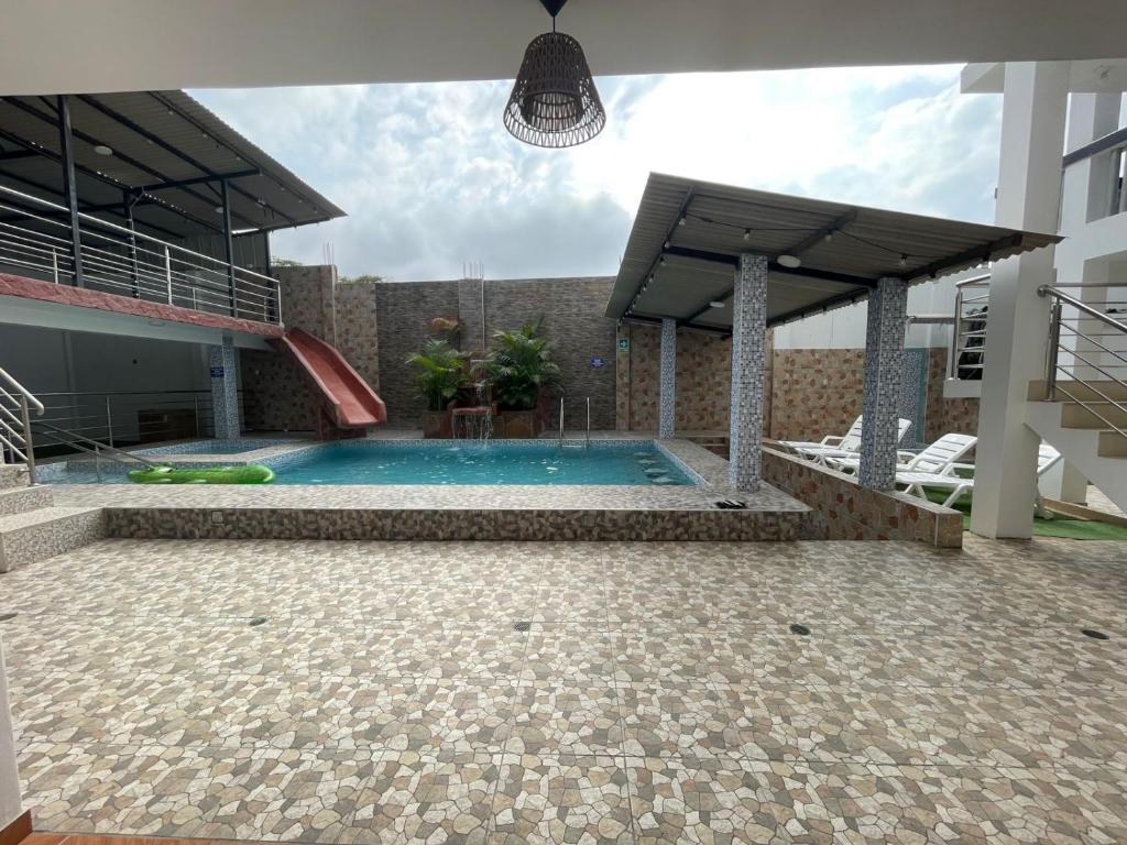 - une piscine avec toboggan dans un bâtiment dans l'établissement Hotel Pinos del Mar, à Zorritos