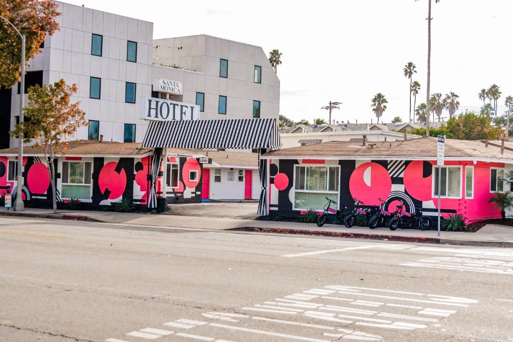 un hotel con vernice rosa e bianca sul lato di una strada di Santa Monica Hotel a Los Angeles
