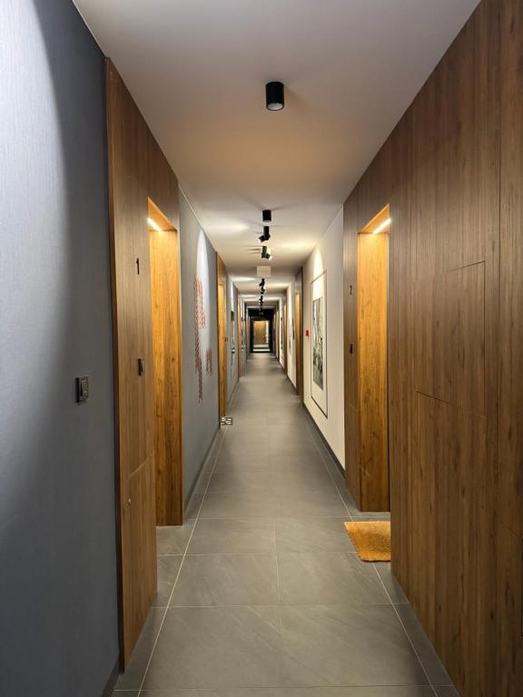 a hallway with wooden doors and a long corridor at Old Town Nadmotławie - Sauna & Gym I 10min deptak in Gdańsk