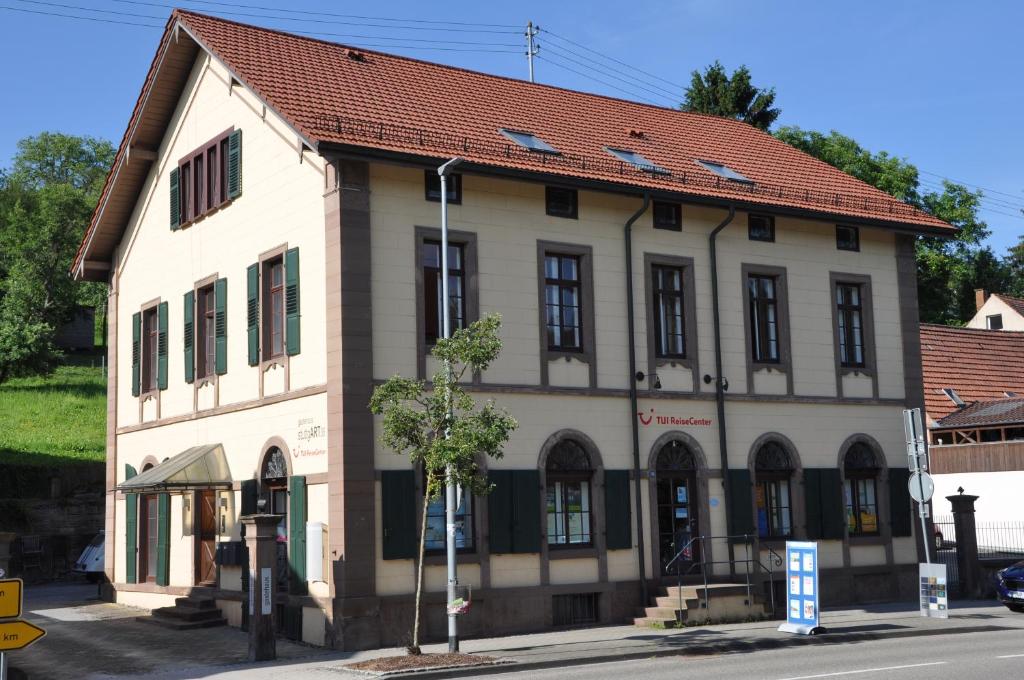 Gästehaus stuttgART36 في ماولبرون: مبنى ابيض كبير بسقف احمر