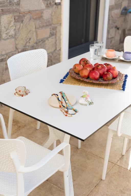 a white table with a plate of apples on it at Lampetos Houses Molyvos in Mythimna