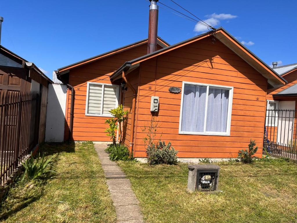 una casa naranja con una ventana en el patio en Casa a 10 minutos del centro Osorno, en Osorno