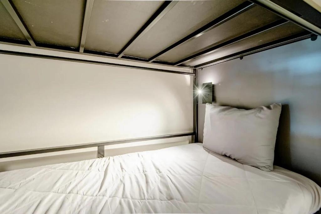 a bed with a white pillow in a room at Cama en habitación Compartida para Hombres in Mexico City