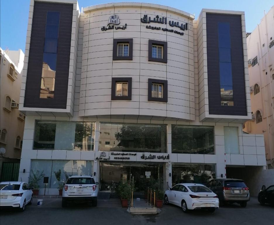 un edificio con coches estacionados frente a él en اريس الشرق للشقق المخدومة en Yeda