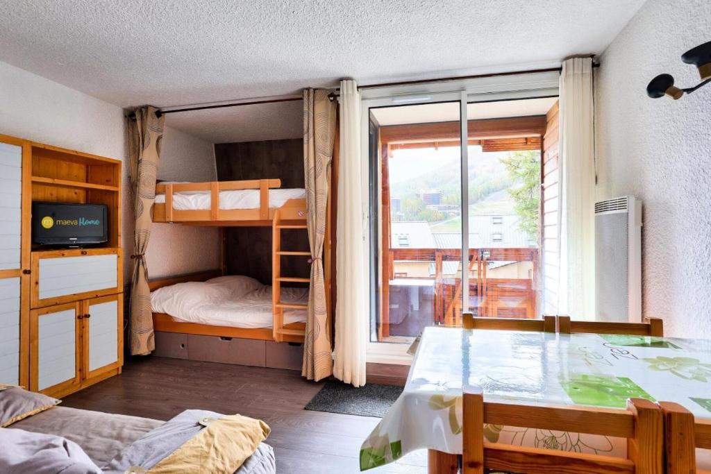 Zimmer mit einem Bett, Etagenbetten und einem Fenster in der Unterkunft Résidence Le Hameau - maeva Home - Studio 4 personnes - Sélection 854 in Vars