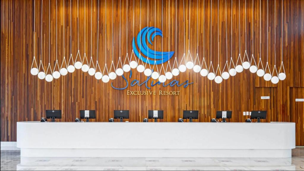 a lobby with a reception desk and a sign on a wooden wall at Salinas Exclusive Resort in Salinópolis