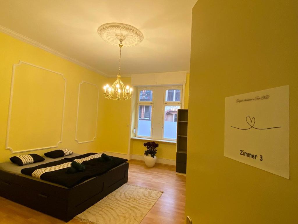 a yellow room with a bed and a window at Modernisierte, traumhafte Wohnung in zentraler Lage in Wiesbaden