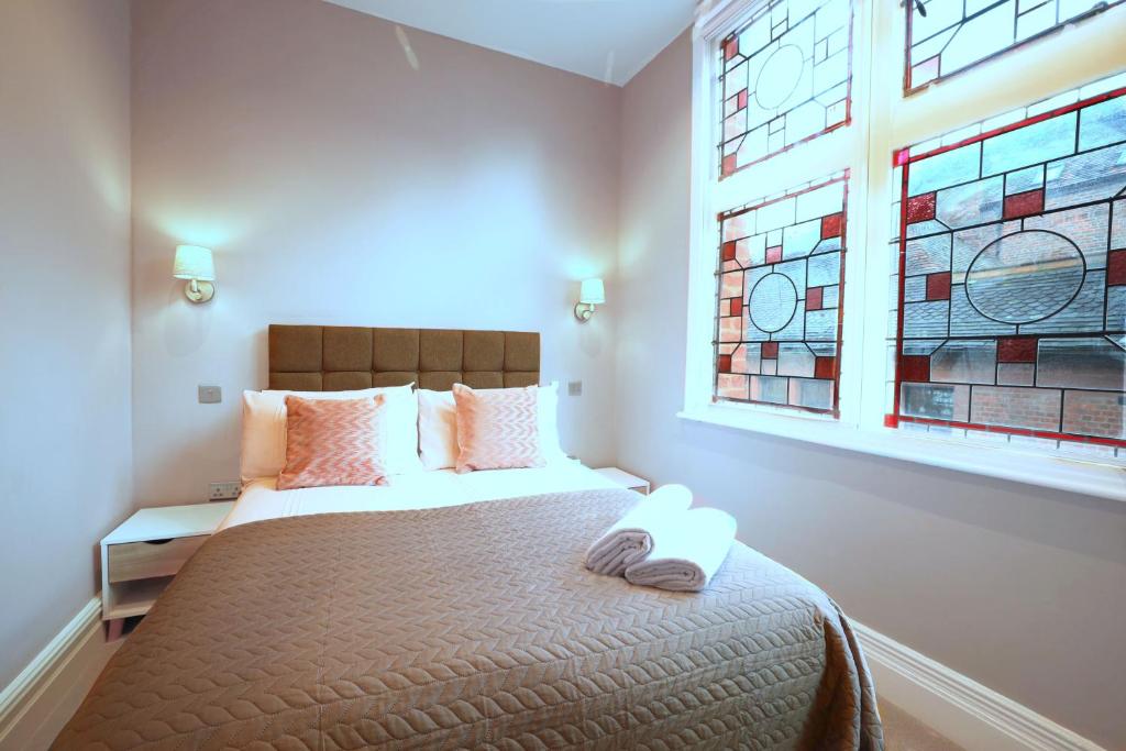 a bedroom with a bed with a large window at Old Market Apartments in Altrincham
