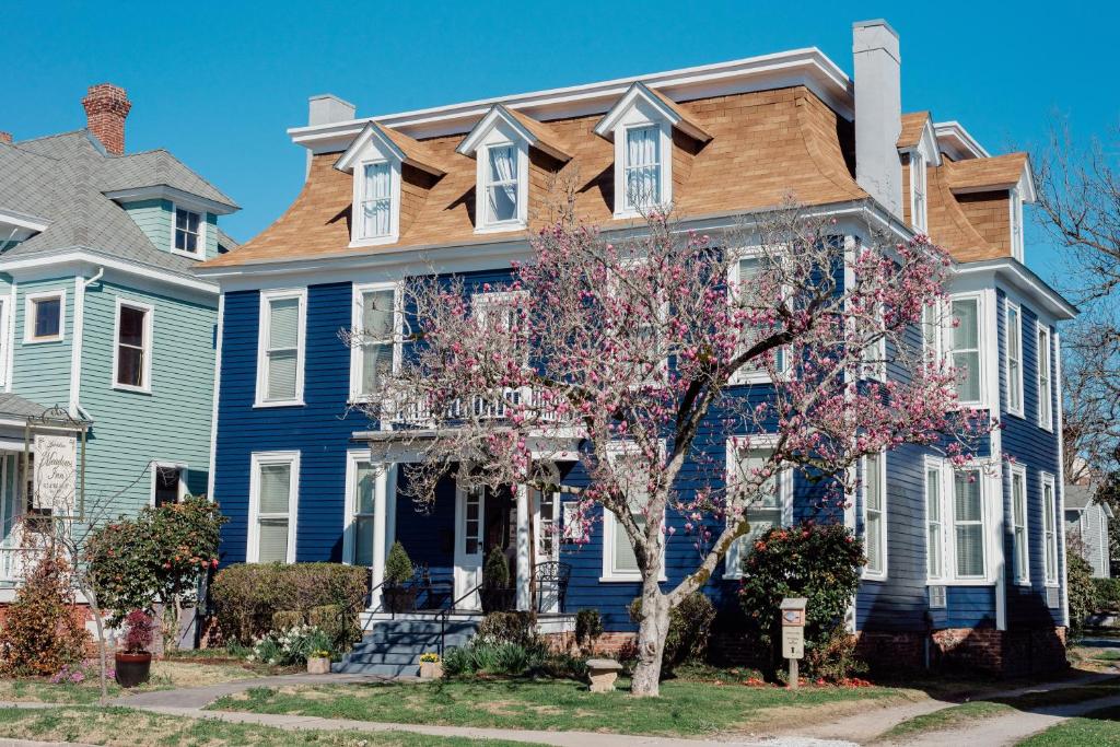 una casa azul con un árbol delante en Meadows Inn en New Bern