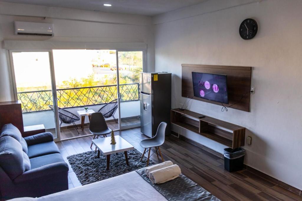 a living room with a couch and a tv on a wall at Lofts Terra Nuevo Vallarta in Nuevo Vallarta