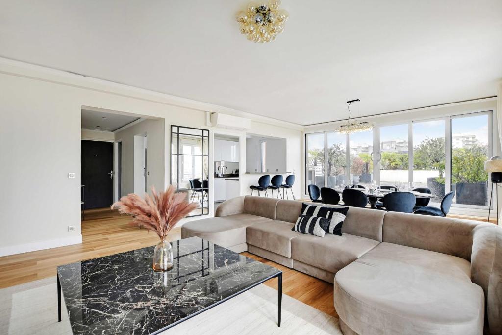 a living room with a couch and a table at Sumptuous apartment with terrace Courbevoie in Courbevoie