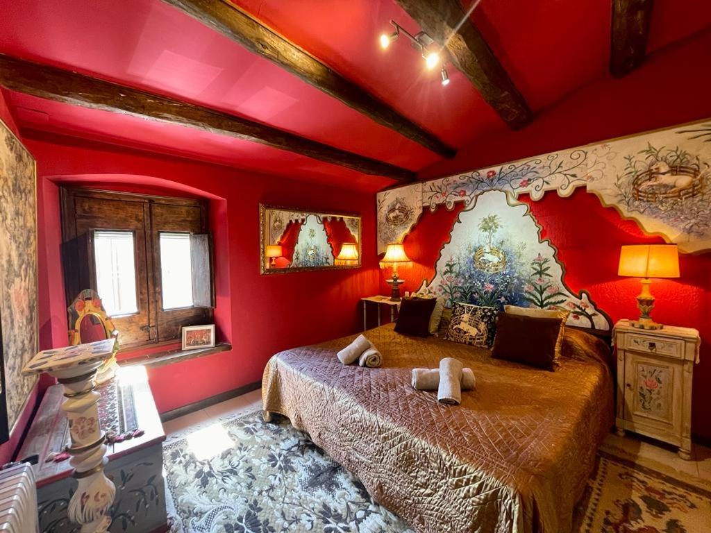 a bedroom with red walls and a bed in a room at La Morada Del Unicornio in Calonge