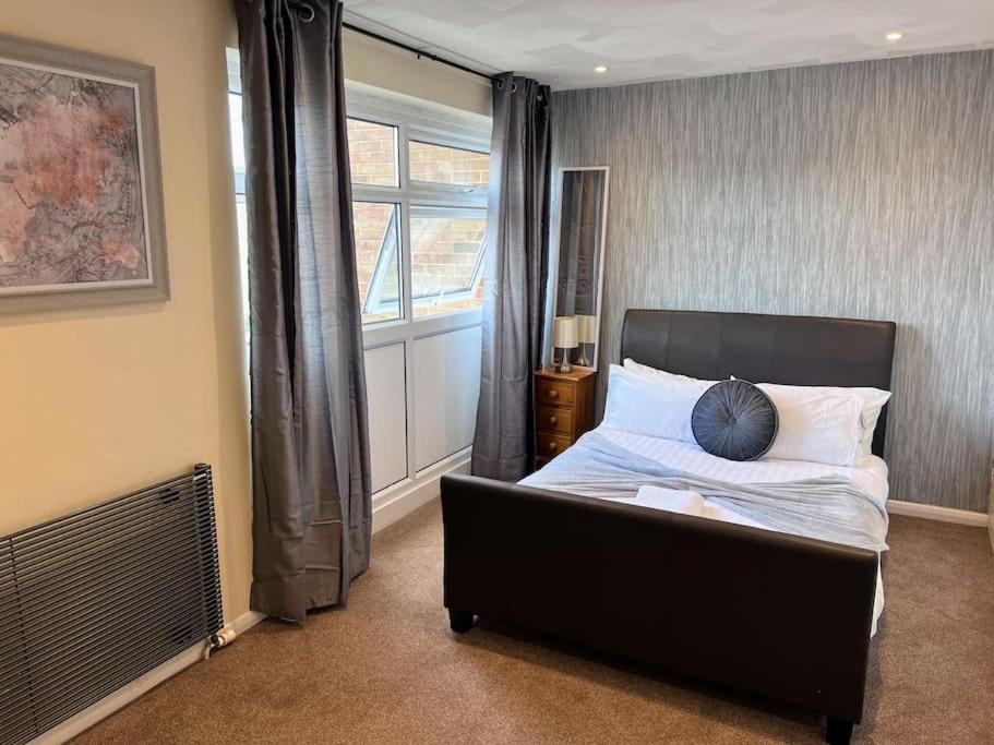 una camera con letto e finestra di 4 Bedroom House by Mesh Accommodation Short Lets Canterbury For Contractors And Corporate Stays For Short & Long Term Stays a Kent