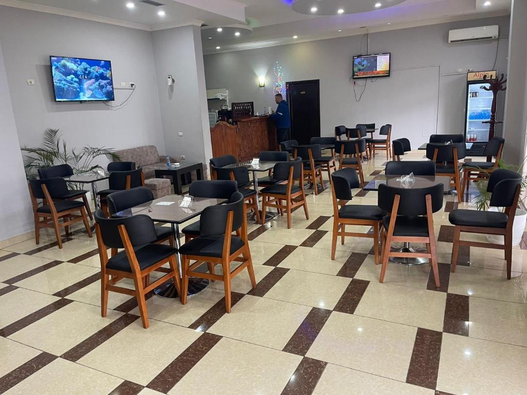 een restaurant met tafels en stoelen en een man in een kamer bij Kokaj3B 