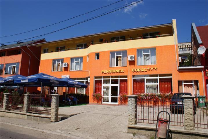 an orange building with a restaurant on a street at Pension Coral in Baia Mare