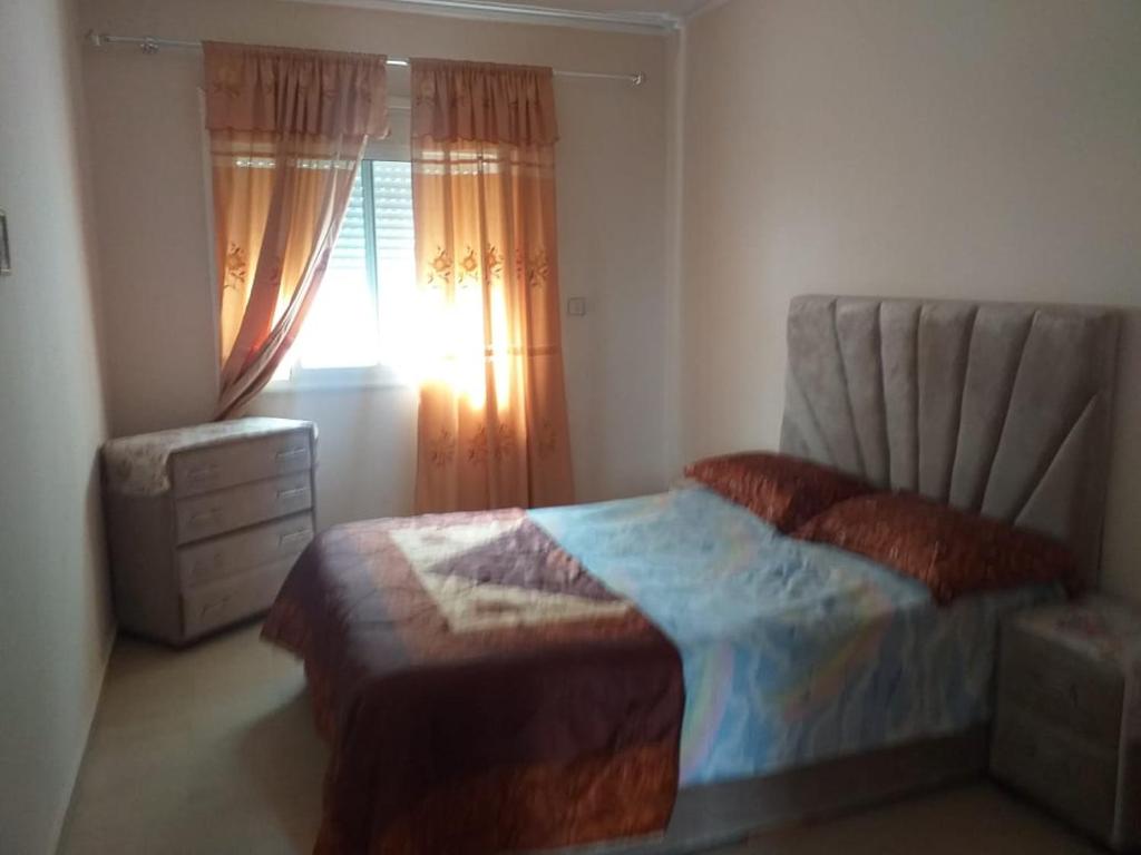 um quarto com uma cama e uma janela em Appartement meublé situé a côté de centre ville em Meknès