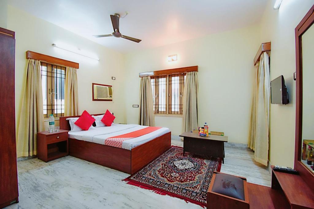 1 dormitorio con 1 cama con almohadas rojas y TV en OYO Retro Residency en Durgāpur